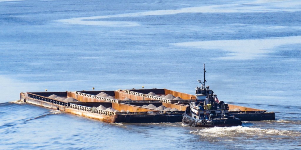 Sarah D tug with six-pack aggregate barges on the waterway